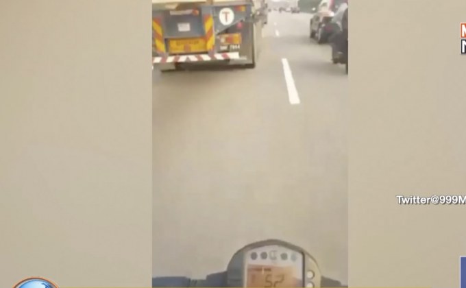 วิจารณ์สนั่น หนุ่มซิ่ง จยย.ลอดใต้รถพ่วง ยกมือถืออัดคลิป