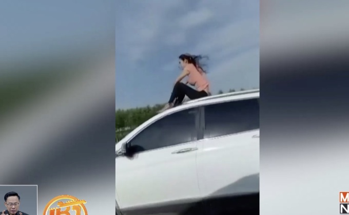 ผู้หญิงจีนนั่งผ่อนคลายบนหลังคารถยนต์