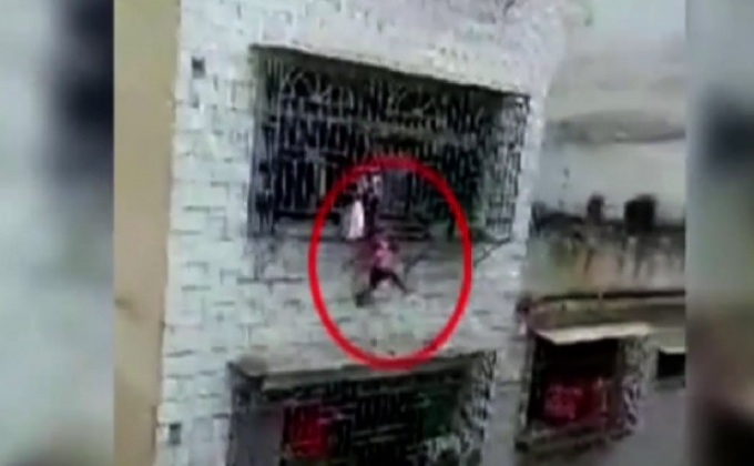 เด็กจีนศีรษะติดเหล็กดัดห้อยตัวนอกหน้าต่างชั้น 4